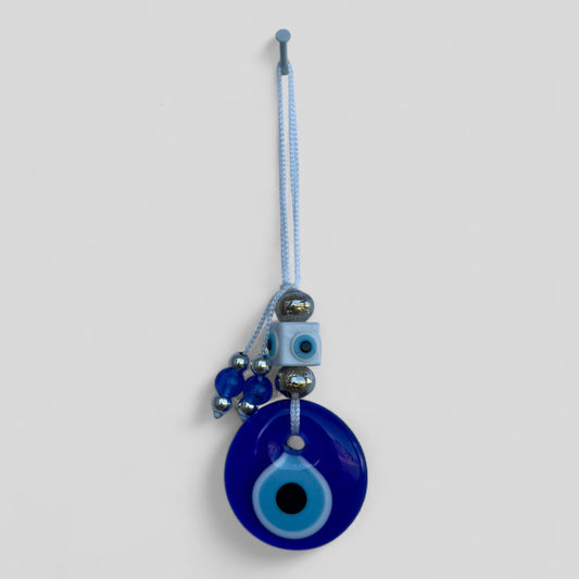 Blue evil eye charm with beads on a white background
