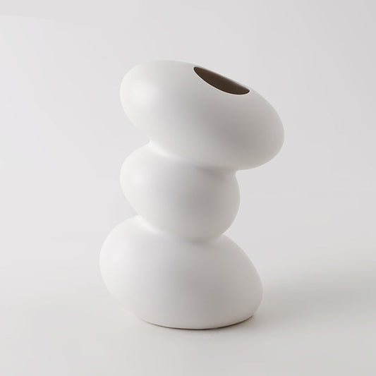 White ceramic vase with a unique design on a light gray background