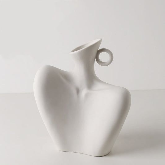 White ceramic vase with a unique design on a light gray background